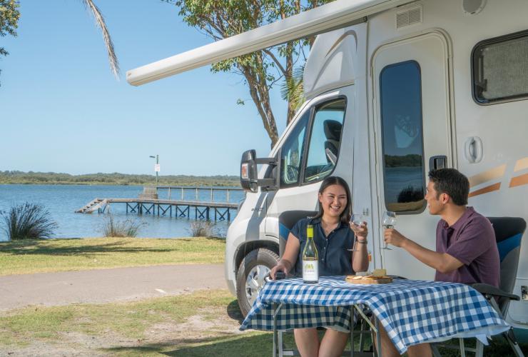 比格佛考拉海岸史蒂芬斯港假日公园，一对情侣在露营车上一边喝酒一边欣赏水景 © 新南威尔士州旅游局版权所有