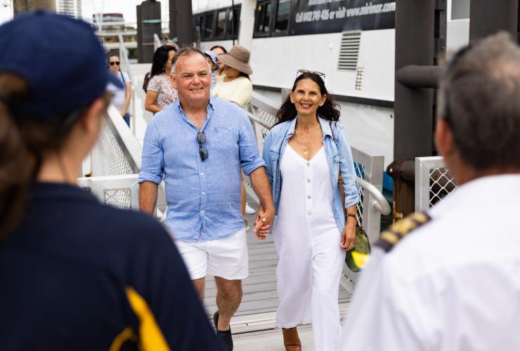昆士兰州，布里斯班，一对老夫妇抵达码头并受到 River City Cruises 工作人员的欢迎 © 澳大利亚旅游局版权所有