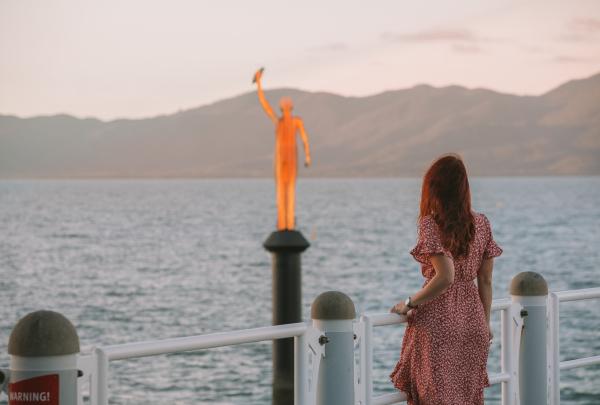 一名女子在汤斯维尔的斯特兰码头欣赏水下艺术博物馆的“海妖”雕塑 © 昆士兰州旅游及活动推广局版权所有