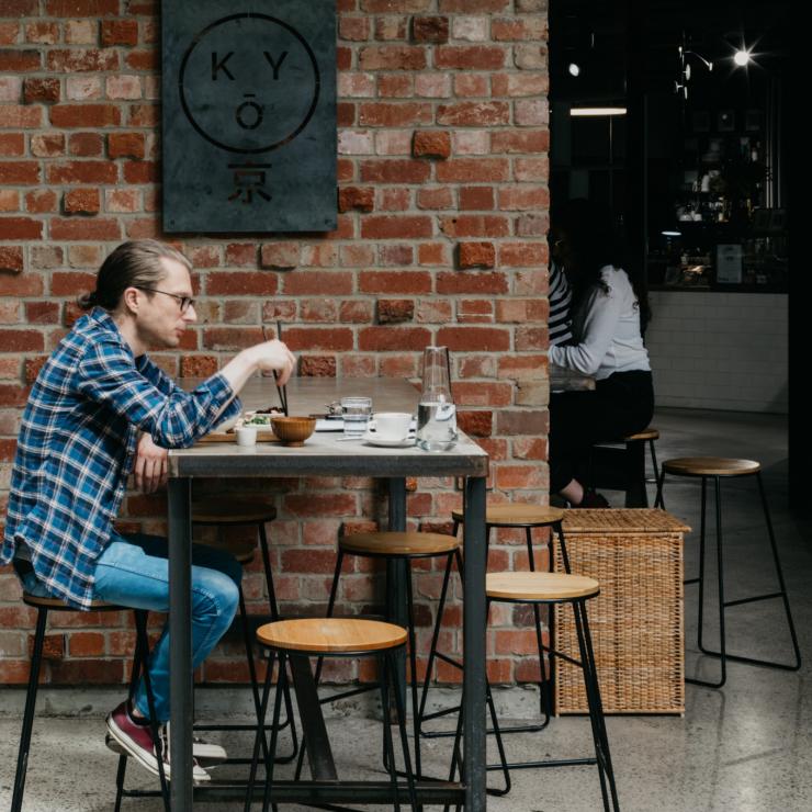 澳大利亚首都领地，堪培拉，一人坐在 Kyō Coffee Project 餐厅的院子里 © 堪培拉观光局版权所有