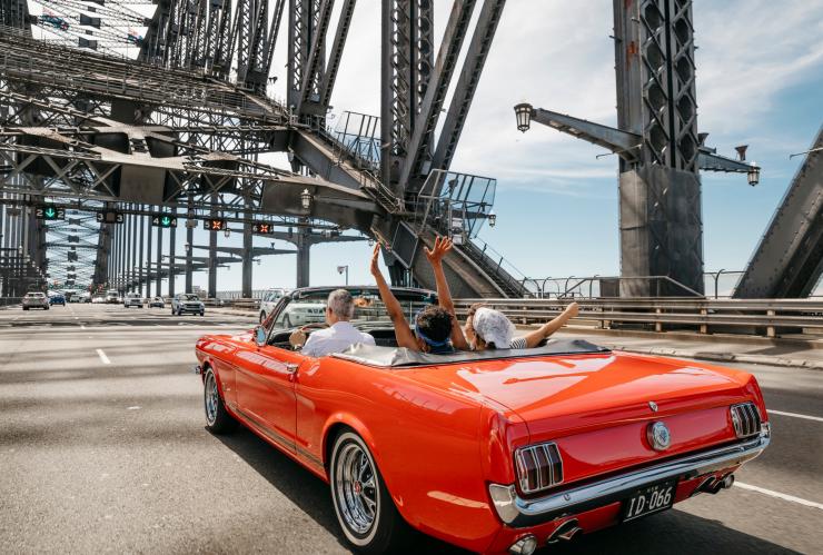 新南威尔士州，悉尼，朋友们开着 Sydney Mustangs Wedding Cars 的敞篷车通过悉尼海港大桥 © 新南威尔士州旅游局版权所有