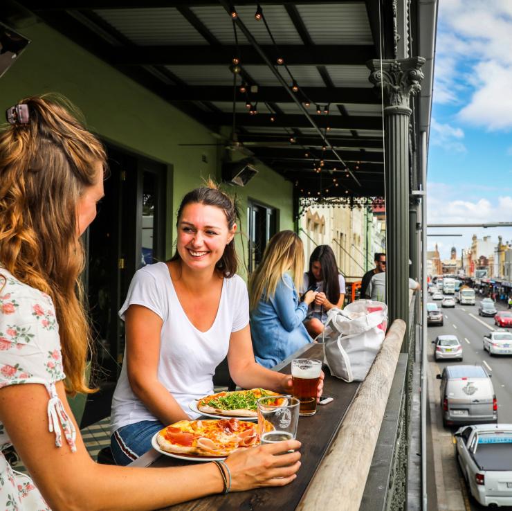 一群朋友在新城镇酒店的阳台上享用批萨和饮料 © 悉尼市政府/Katherine Griffiths 版权所有
