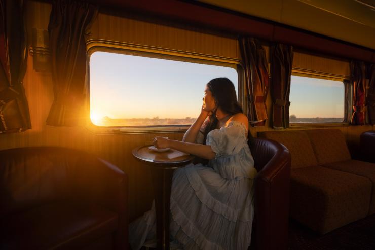一位女士在“甘号”列车上品尝热饮 © 北领地旅游局/Daniel Tran 版权所有
