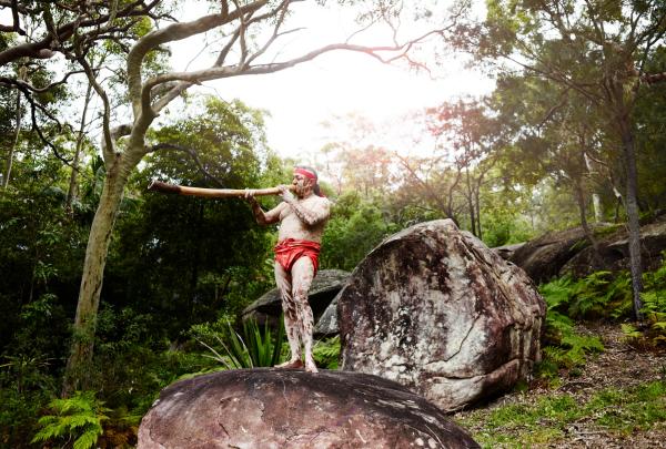 新南威尔士州，波蒂国家公园，皮利特海滩别墅，在岩石上演奏迪吉里杜管 © 皮利特海滩别墅版权所有