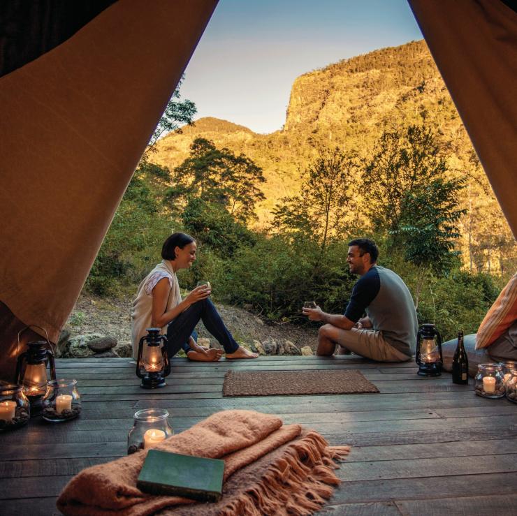 一对情侣坐在昆士兰州 Nightfall 豪华露营的帐篷里 © Nightfall 版权所有