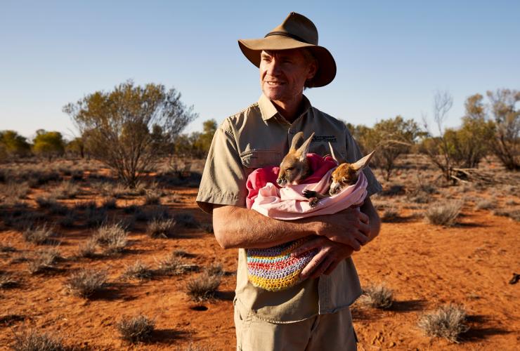 克里斯 · 布罗加 · 巴恩斯在袋鼠保护区里抱着一只袋鼠宝宝 © 澳大利亚旅游局版权所有