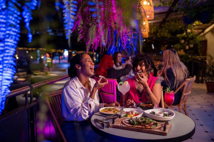 新南威尔士州，在悉尼 Pumphouse 餐厅和酒吧，两位女士一边享用美食和鸡尾酒，一边谈笑风生 © 新南威尔士州旅游局版权所有