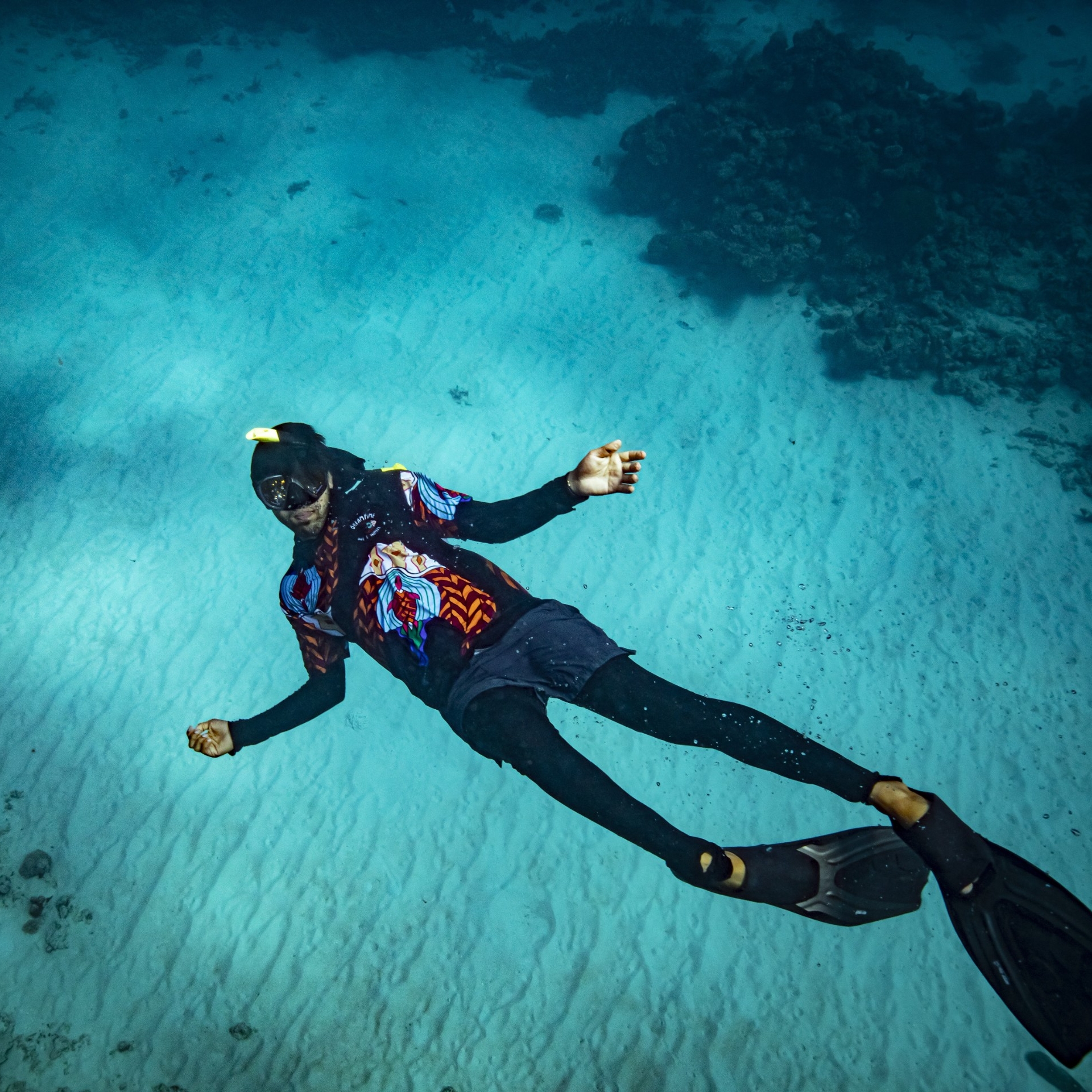 佩戴着浮潜装备和脚蹼的梦幻时光潜水和浮潜之旅向导在大堡礁游泳 © Archie Sartracom/澳大利亚旅游局版权所有