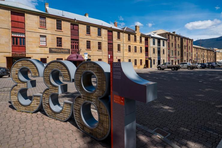 塔斯马尼亚州，霍巴特，“1833”字样的木头和金属材质雕塑，背景中是一条砖砌小径和一排建筑 © 澳大利亚旅游局版权所有