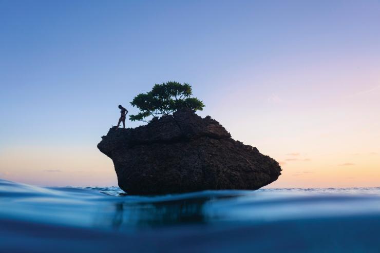 圣诞岛，飞鱼湾，一个人站在海中的岩石上 © 圣诞岛旅游协会版权所有
