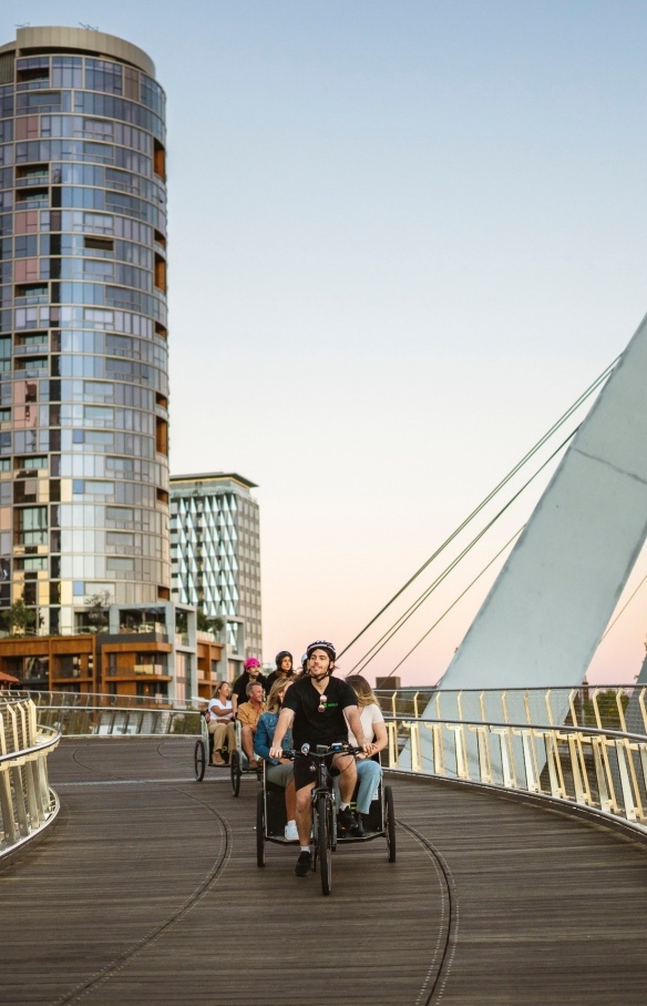 西澳大利亚州，珀斯，参加 Peddle Perth 的一群游客在夜晚乘坐三轮车穿越大桥 © 澳大利亚旅游局版权所有