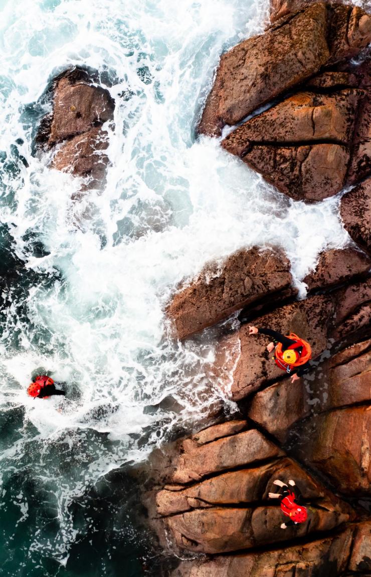 西澳大利亚州，玛格丽特河，俯瞰一群人在玛格丽特河探险公司推出的体验活动中爬上海浪拍打的岩石，跳入大海 © 玛格丽特河探险公司/Sarah Hewer Photography 版权所有