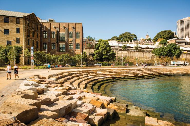 新南威尔士州，悉尼，人们在通向水边的砂岩台阶旁的海港小径上闲坐、跑步或散步 © 新南威尔士州旅游局版权所有