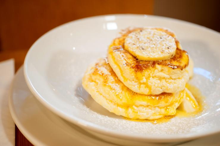 新南威尔士州，悉尼，达令赫斯特，Bills 餐厅，一只盛放着乳清芝士热蛋糕的盘子，蛋糕顶上浇有金黄色蜂窝黄油 © 澳大利亚旅游局版权所有