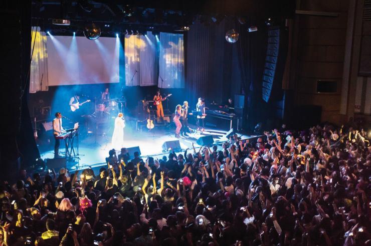 新南威尔士州，悉尼，Enmore 剧院，缤纷悉尼灯光音乐节，乐队在蓝色灯光下表演，舞台下的观众随着音乐手舞足蹈 © 新南威尔士州旅游局版权所有