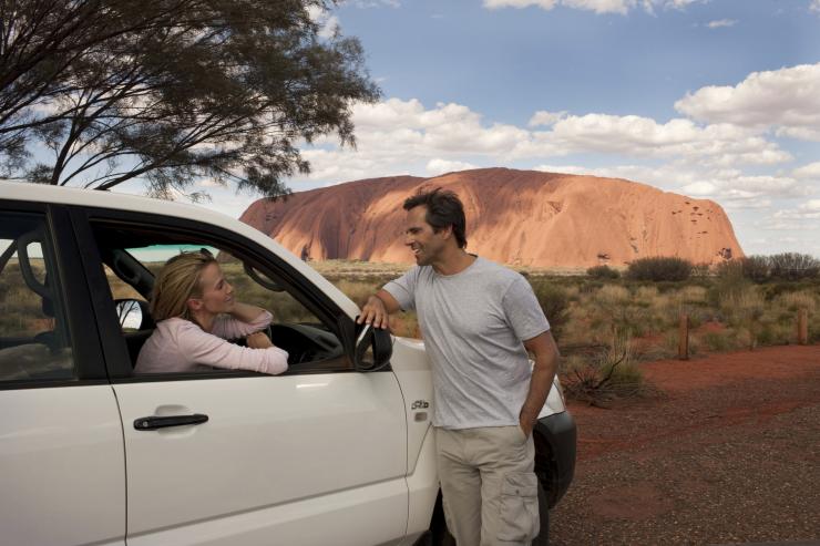 一对情侣坐在停在乌鲁鲁附近的车里 © 澳大利亚旅游局版权所有