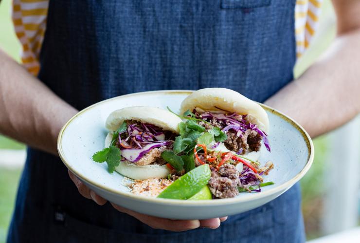 北领地，达尔文，鲷鱼岩，一个人手里端着一盘海鲜包 © 北领地旅游局版权所有