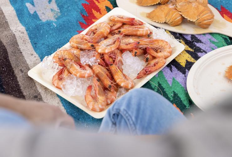 昆士兰州，黄金海岸，Fishermen's Co-op，一盘新鲜大虾放在野餐毯上 © 澳大利亚旅游局版权所有
