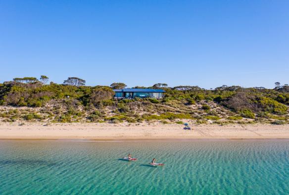 南澳大利亚州，袋鼠岛，One Kangaroo Island 度假屋，两个人在海滨居所附近的海面上悠闲地划着皮艇 © 南澳大利亚旅游局版权所有