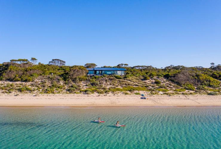 南澳大利亚州，袋鼠岛，One Kangaroo Island 度假屋，两个人在海滨居所附近的海面上悠闲地划着皮艇 © 南澳大利亚旅游局版权所有